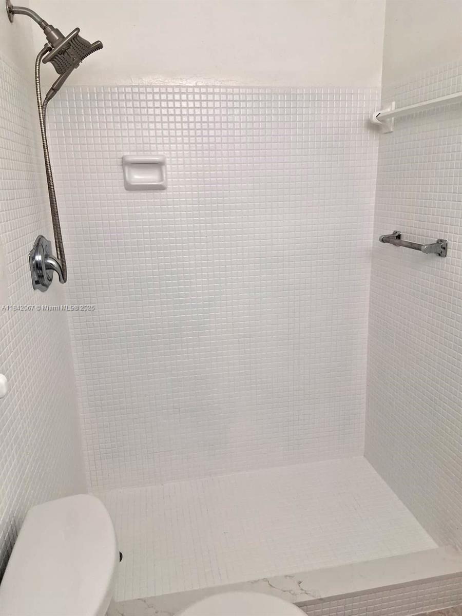 16801 Northeast 14th Avenue, Unit 209 Miami, FL 33162 - Photo 19 of 28 a bathroom with a shower and a toilet