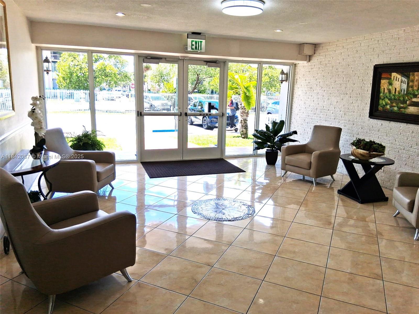 16801 Northeast 14th Avenue, Unit 209 Miami, FL 33162 - Photo 23 of 28 a living room with couches a coffee table and a large window with garden view
