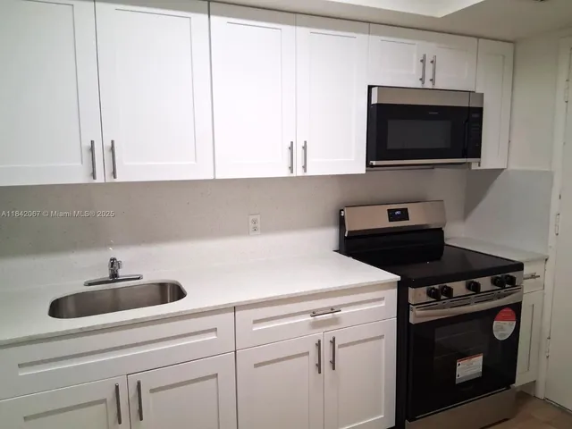 a kitchen with a refrigerator sink and cabinets