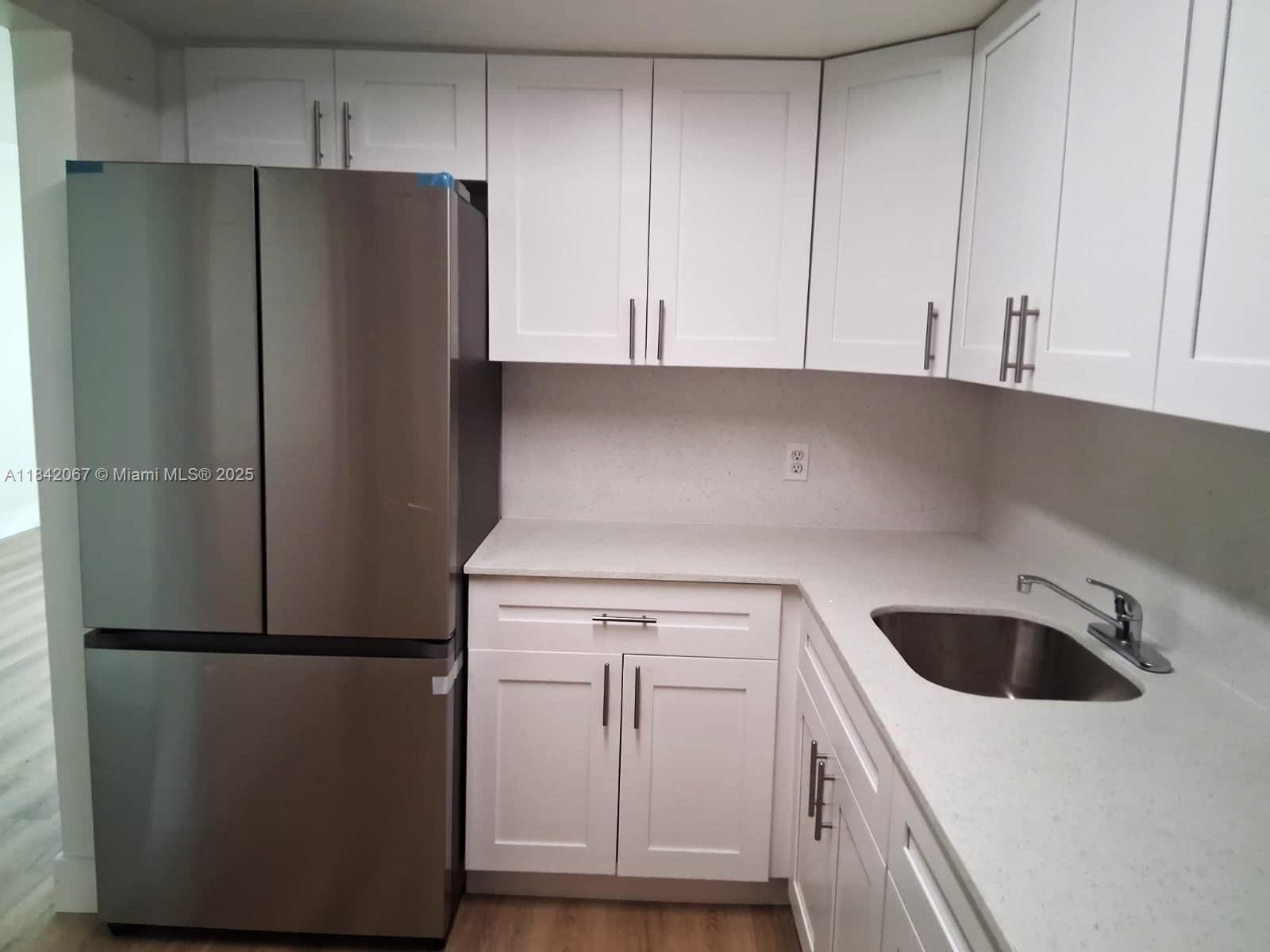 16801 Northeast 14th Avenue, Unit 209 Miami, FL 33162 - Photo 8 of 28 a kitchen with a refrigerator sink and cabinets