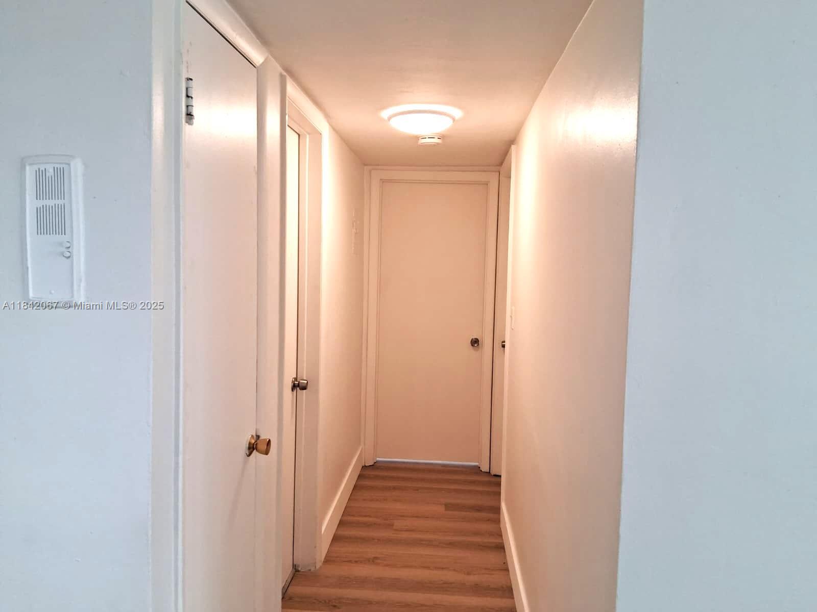 16801 Northeast 14th Avenue, Unit 209 Miami, FL 33162 - Photo 10 of 28 a view of a hallway with wooden floor