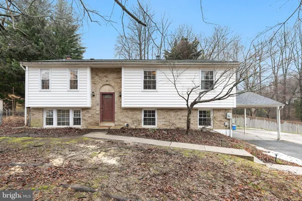 a view of a white house with a large windows next to a yard