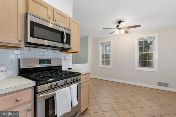 a kitchen with stainless steel appliances granite countertop a stove a microwave and window