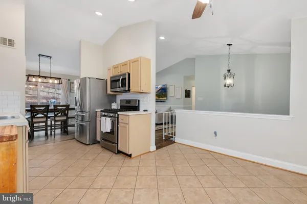 a kitchen with a sink a counter top space stainless steel appliances and cabinets