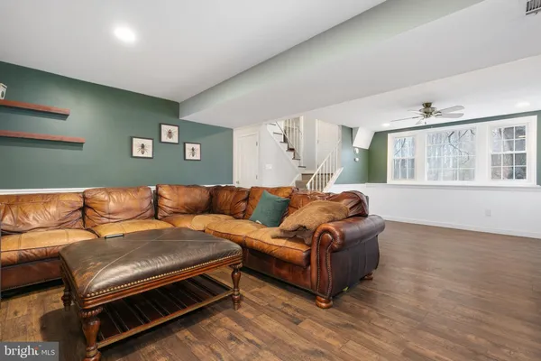 a living room with a couch wooden floor and a window