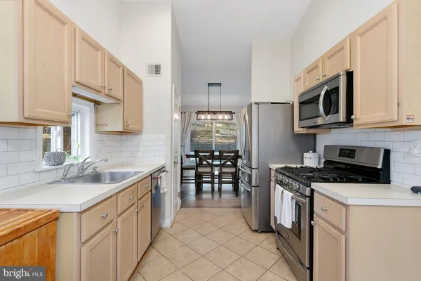 a kitchen with stainless steel appliances a stove sink microwave and cabinets