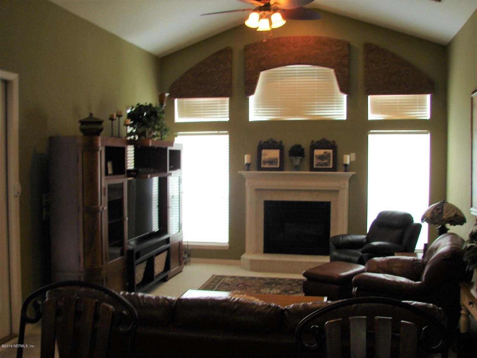 1535 Royal County Drive Jacksonville, FL 32221 - Photo 7 of 38 a living room with furniture a fireplace and a flat screen tv