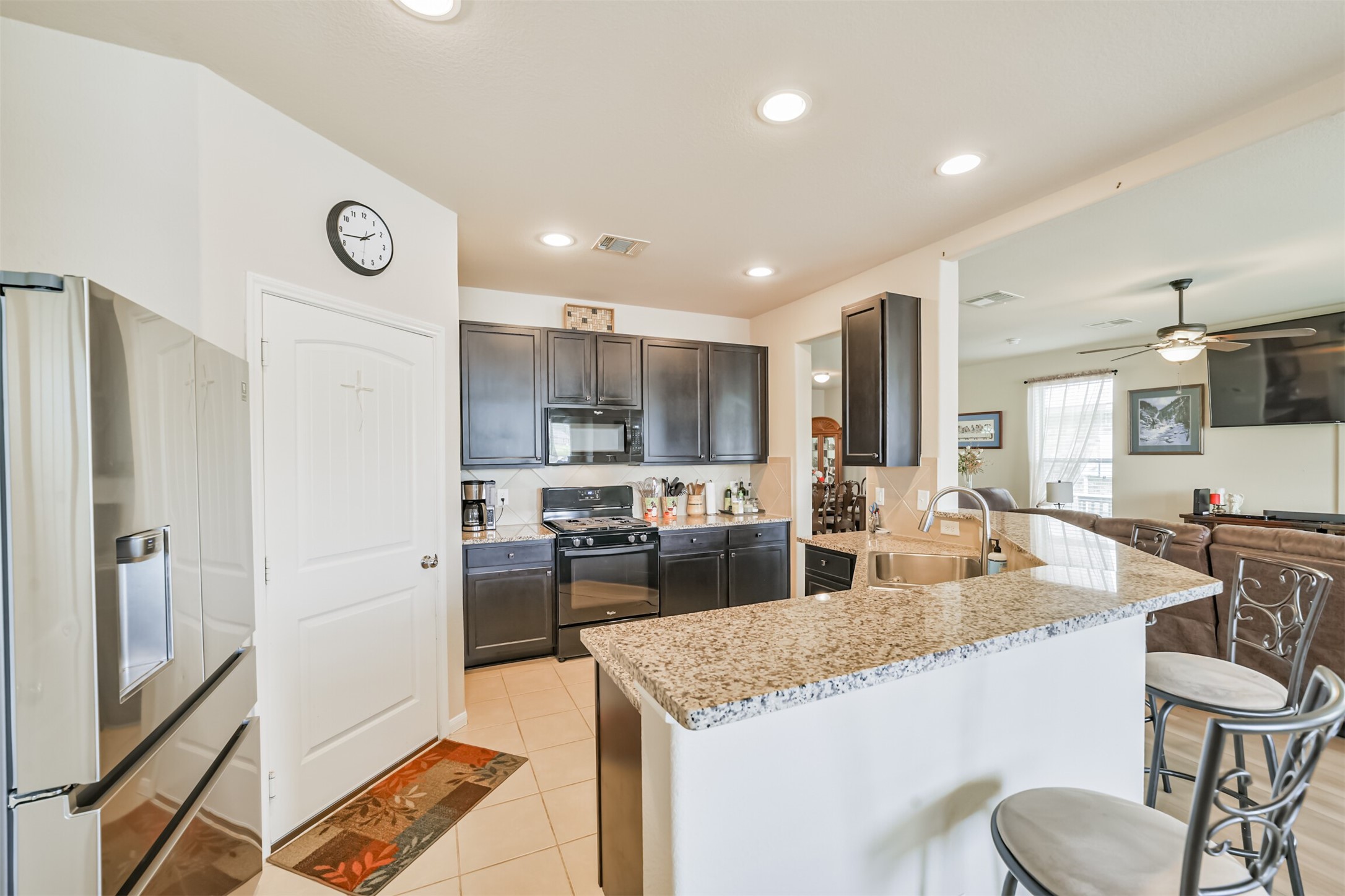 12009 La Salle River Road Conroe, TX 77304 - Photo 21 of 50 a kitchen with stainless steel appliances granite countertop a sink stove and refrigerator