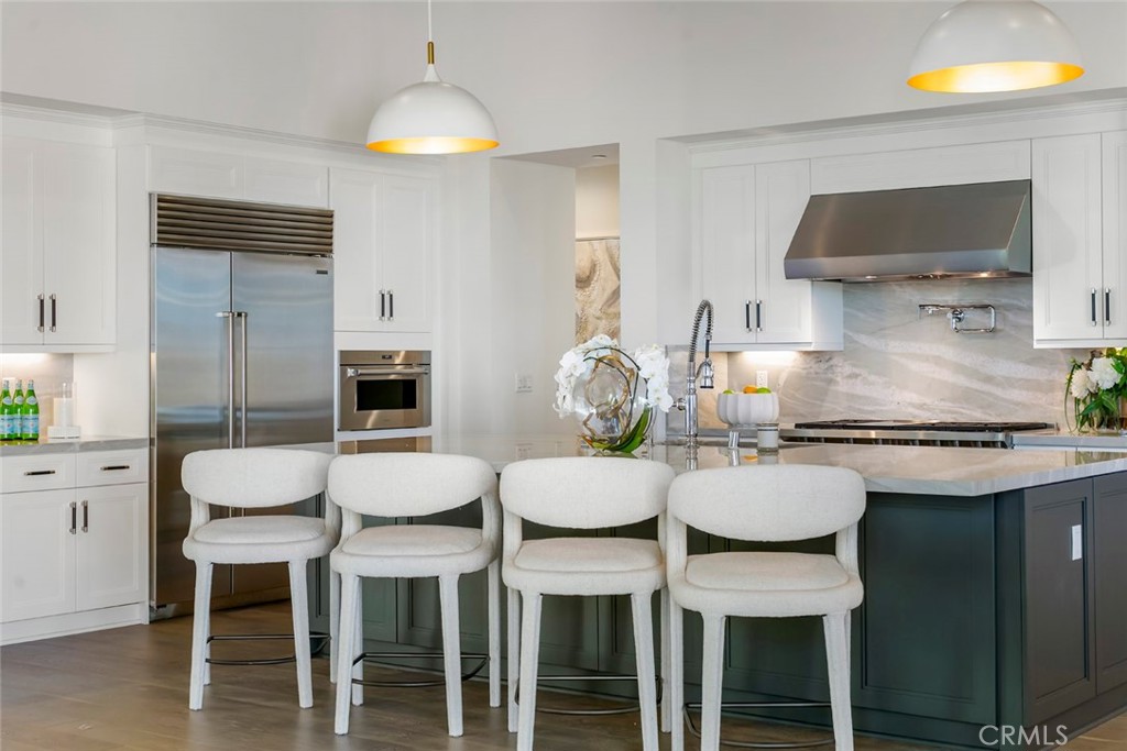 5 Rancho Elastico Road Rolling Hills Estates, CA 90274 - Photo 19 of 48 a kitchen with a dining table chairs and stove