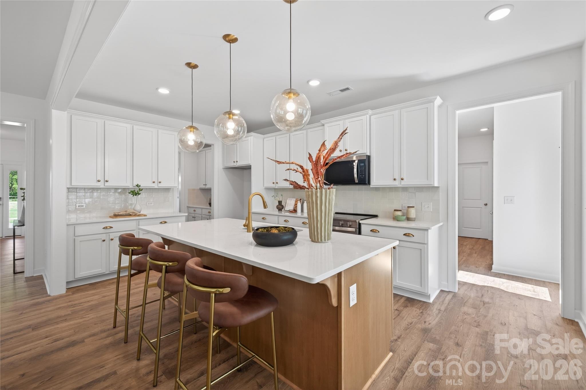 128 Overcash Road, Unit 7171 Troutman, NC 28166 - Photo 5 of 41 a kitchen with kitchen island a island a stove a refrigerator and a chandelier