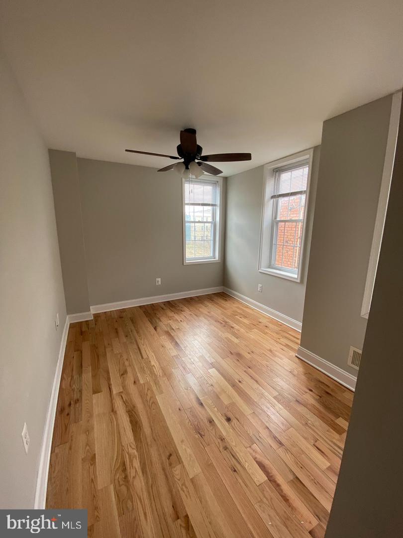 325 East 21st Street Baltimore, MD 21218 - Photo 14 of 28 a view of empty room with wooden floor and fan