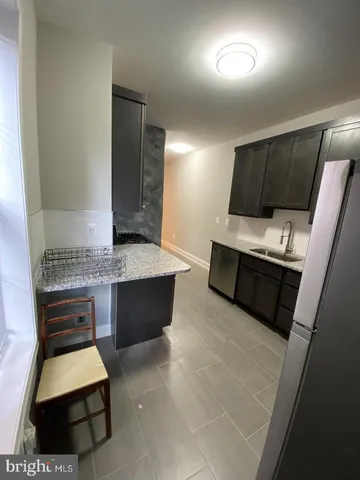 a living room with stainless steel appliances furniture a rug and a window