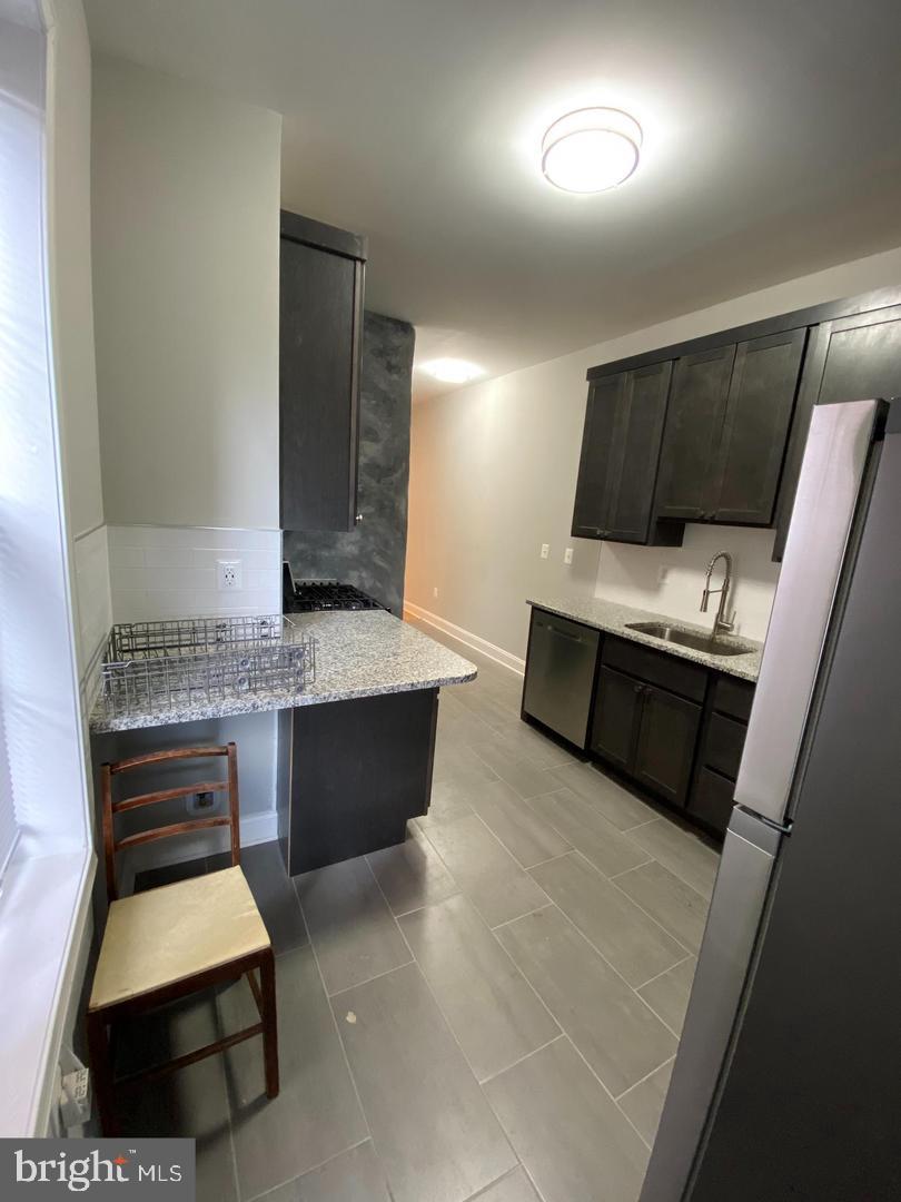 325 East 21st Street Baltimore, MD 21218 - Photo 9 of 28 a living room with stainless steel appliances furniture a rug and a window