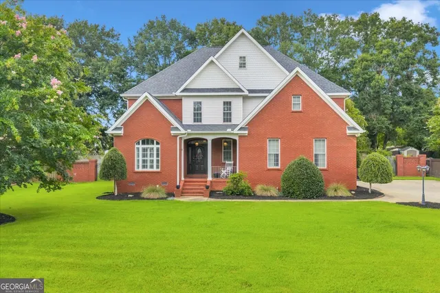 a front view of a house with a yard and trees
