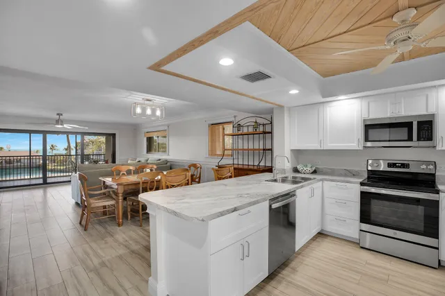 a open kitchen with stainless steel appliances granite countertop a stove and a refrigerator