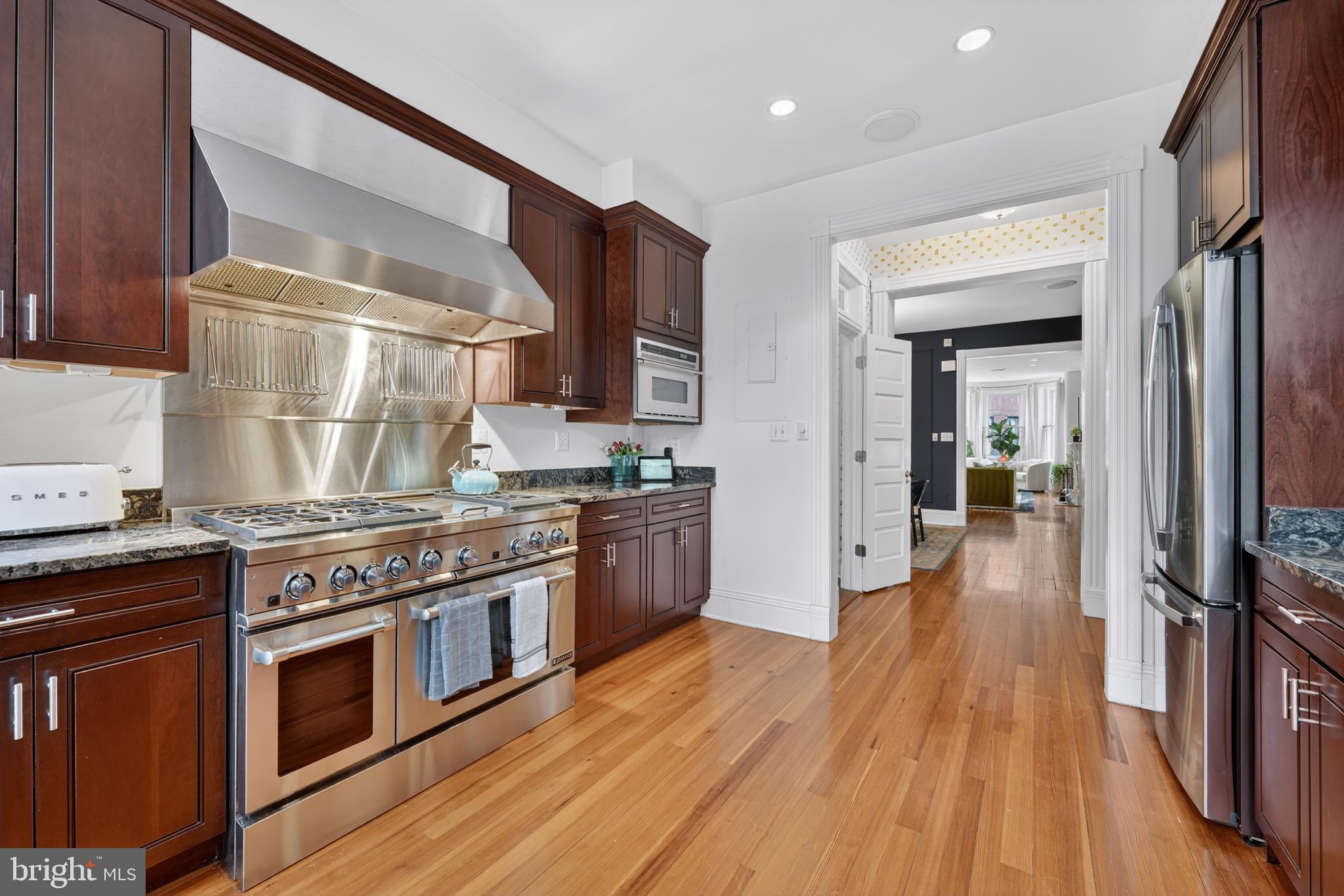 1731 Riggs Place Northwest, Unit 1 Washington, DC 20009 - Photo 15 of 20 a kitchen with stainless steel appliances wooden floors and stove