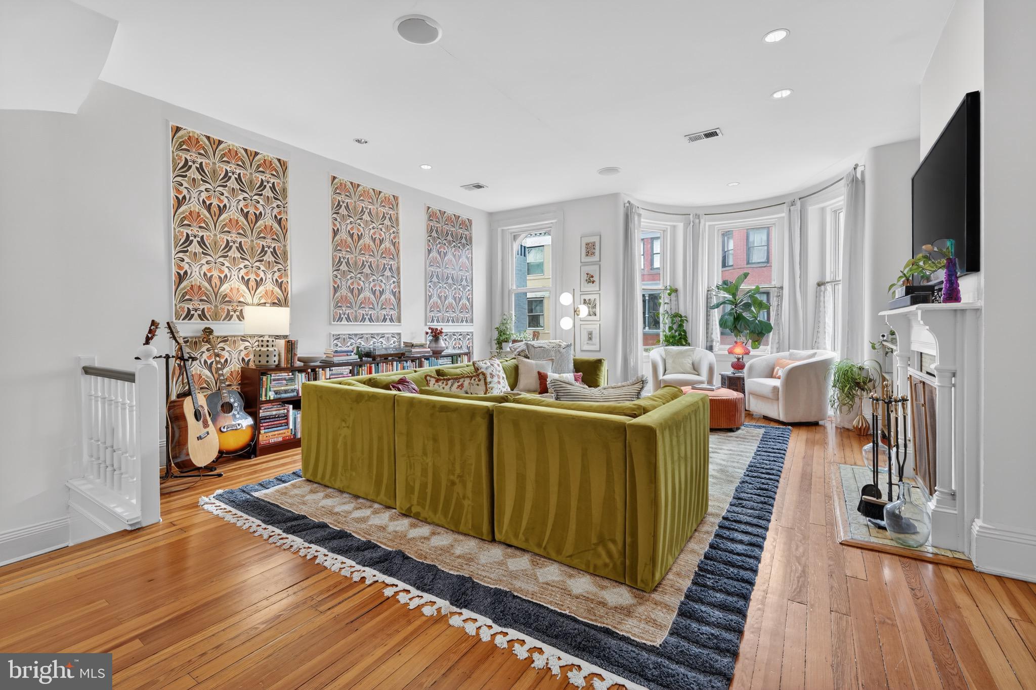1731 Riggs Place Northwest, Unit 1 Washington, DC 20009 - Photo 18 of 20 a living room with furniture a flat screen tv and a floor to ceiling window