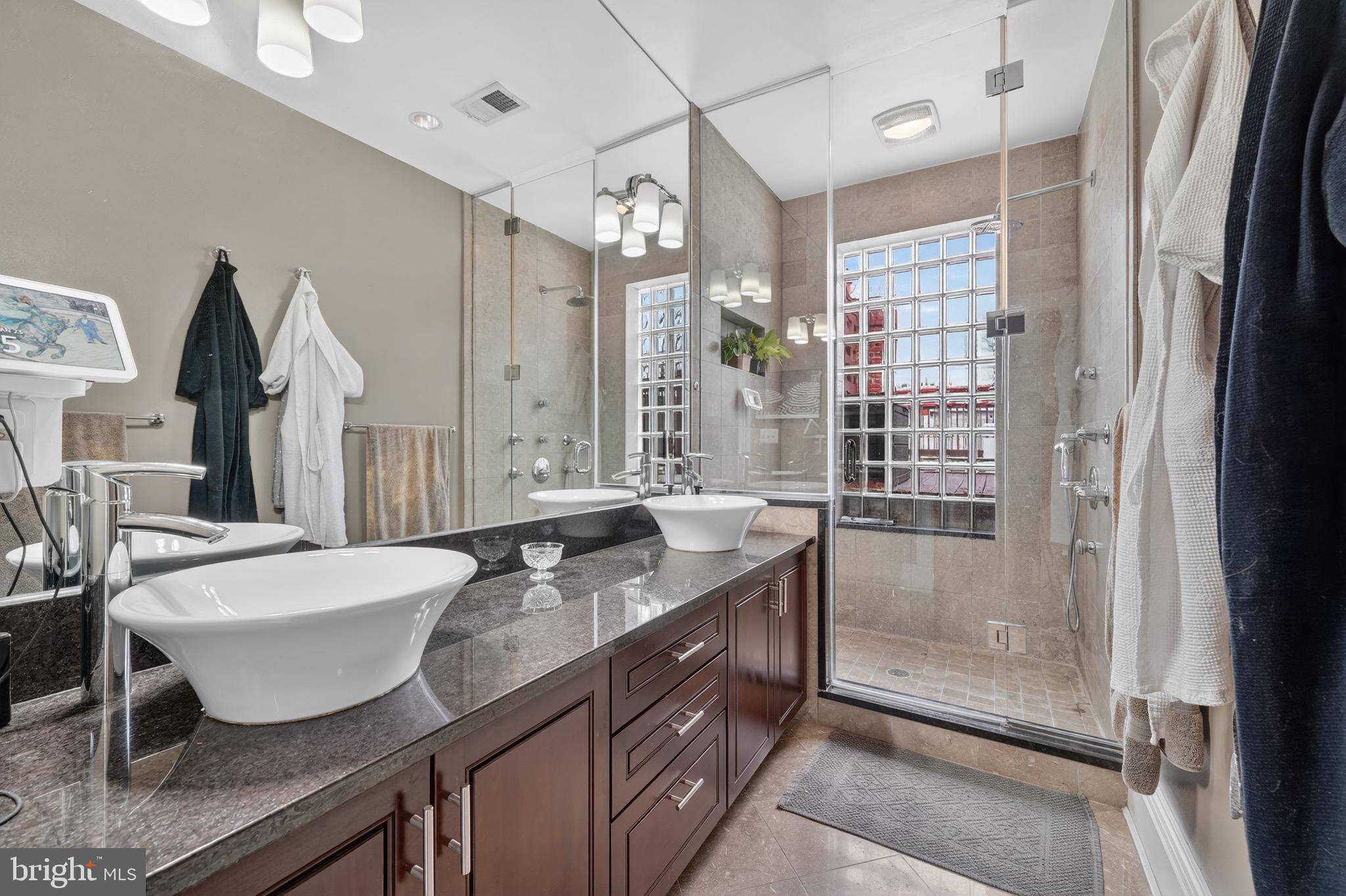 1731 Riggs Place Northwest, Unit 1 Washington, DC 20009 - Photo 2 of 20 a spacious bathroom with a granite countertop sink a mirror and a shower