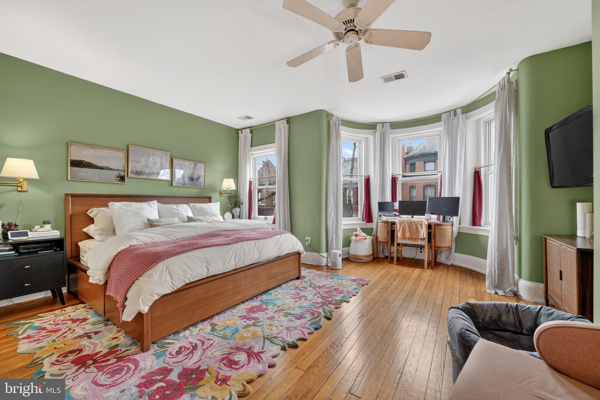 1731 Riggs Place Northwest, Unit 1 Washington, DC 20009 - Photo 9 of 20 a bedroom with a bed couch and a flat screen tv