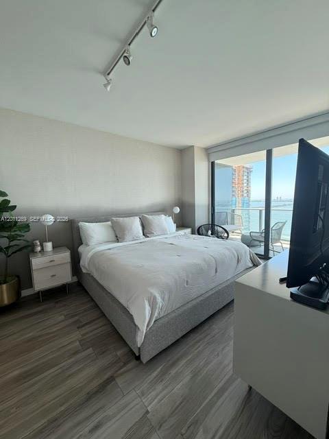 460 Northeast 28th Street, Unit 3408 Miami, FL 33137 - Photo 23 of 37 a bedroom with a bed flat screen tv and a large window