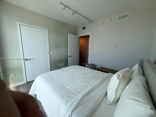 460 Northeast 28th Street, Unit 3408 Miami, FL 33137 - Photo 9 of 37 a bedroom with a bed and a mirror