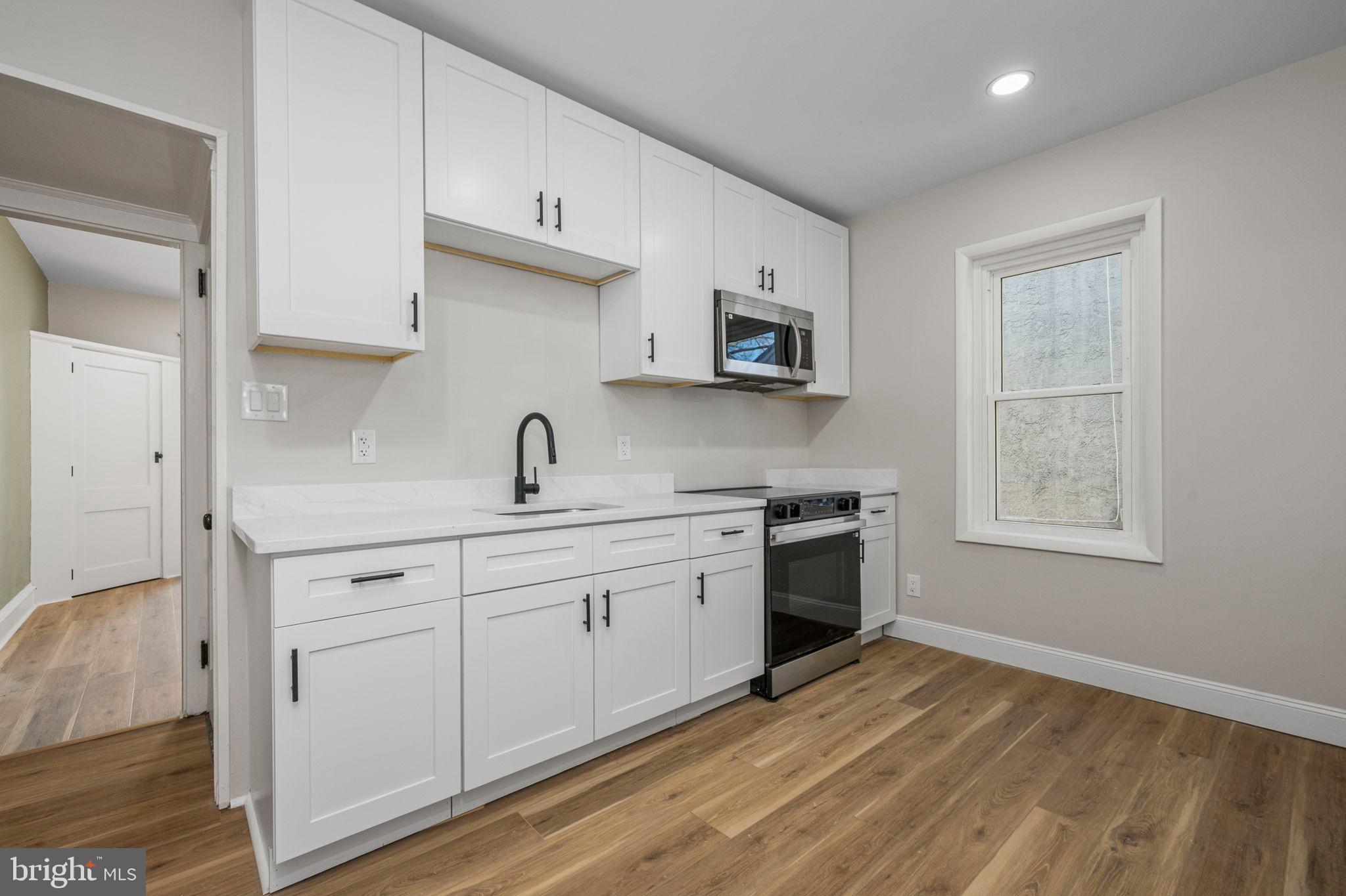 207 George Street Reading, PA 19605 - Photo 8 of 22 Modern kitchen with sleek white cabinetry.