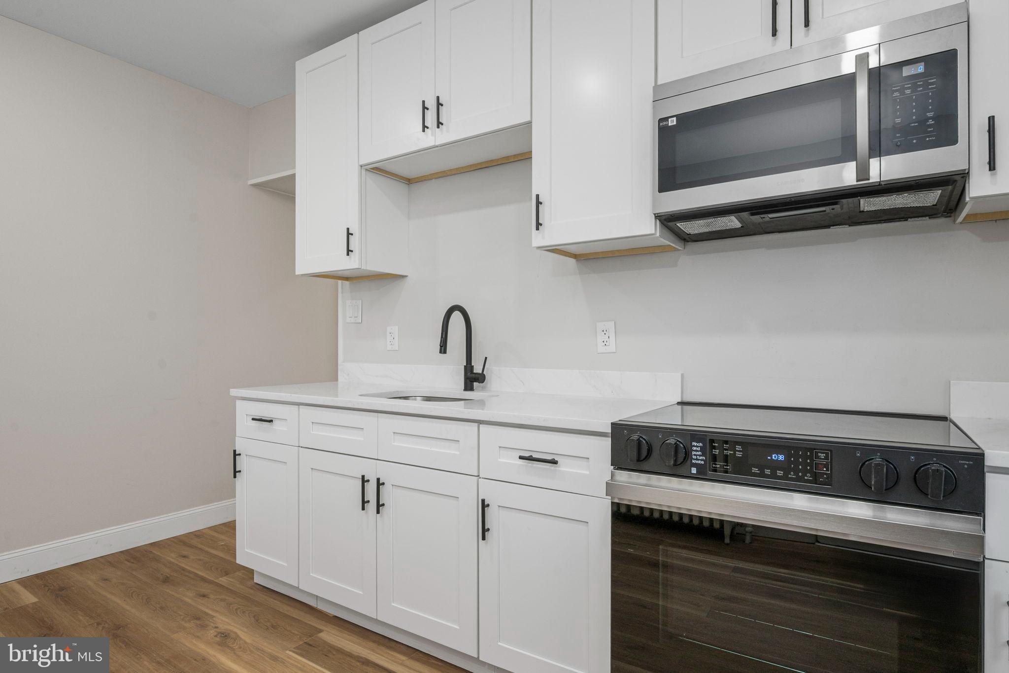 207 George Street Reading, PA 19605 - Photo 9 of 22 Modern kitchen with sleek white cabinetry.