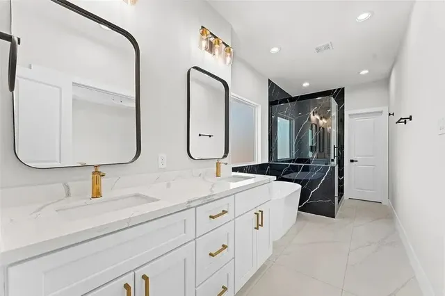 a bathroom with double vanity sinks double vanity tub shower and a mirror