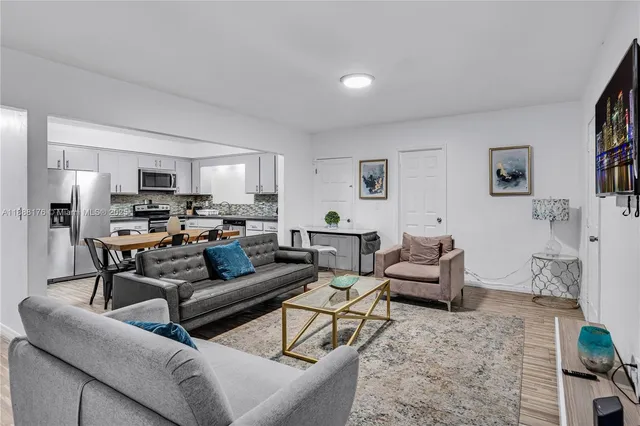 a living room with furniture and a view of kitchen