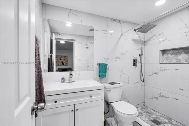 a bathroom with a sink toilet vanity and shower