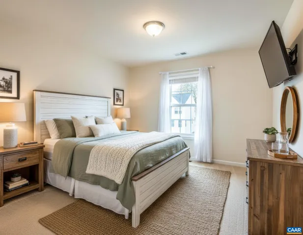a bedroom with a bed and a flat tv screen on a dresser