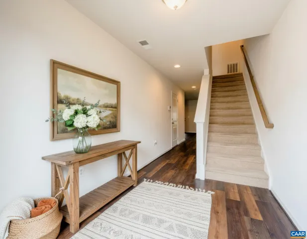 a view of entryway and hall with wooden floor