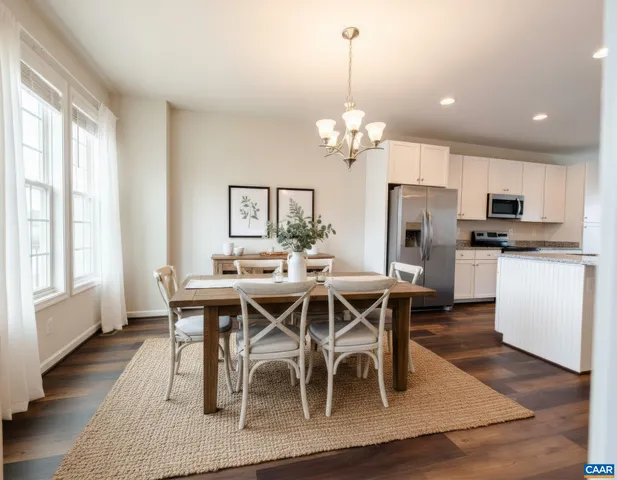 a view of a dining room with furniture a kitchen and chandelier
