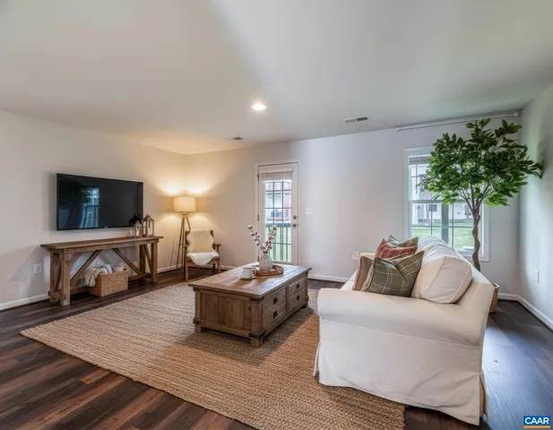 a living room with furniture a flat screen tv and a large window