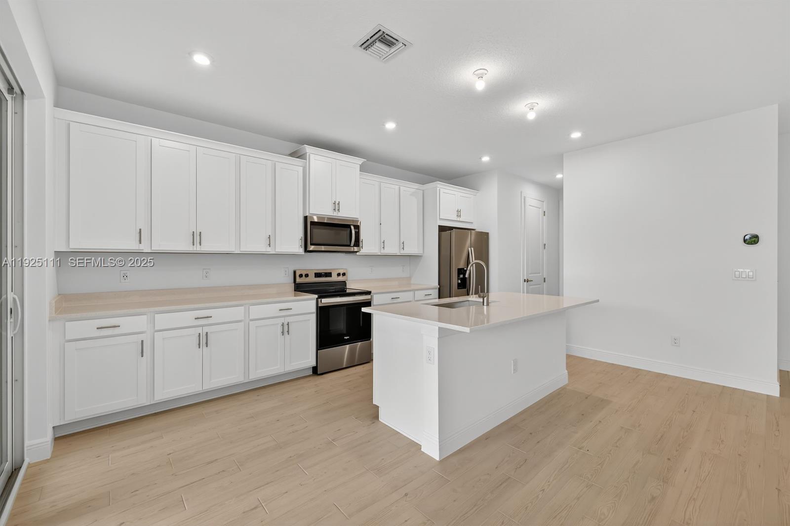 a kitchen with white cabinets and stainless steel appliances