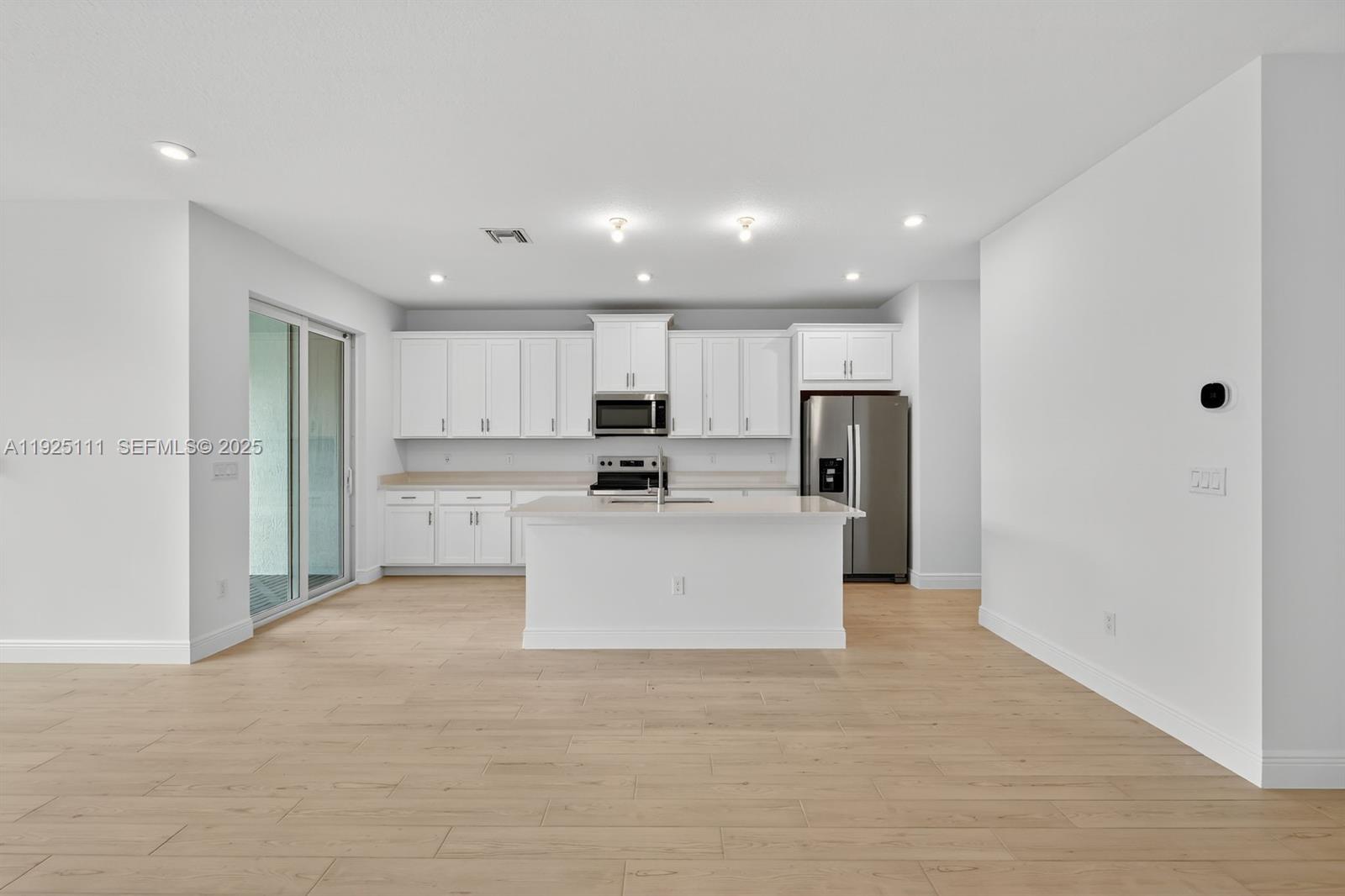 3585 Northwest Solange Court, Unit 3585 Jensen Beach, FL 34957 - Photo 11 of 33 a large white kitchen with stainless steel appliances kitchen island a stove a refrigerator a sink and a stove