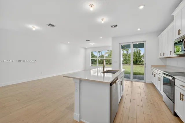 a kitchen with kitchen island a sink and wooden floor