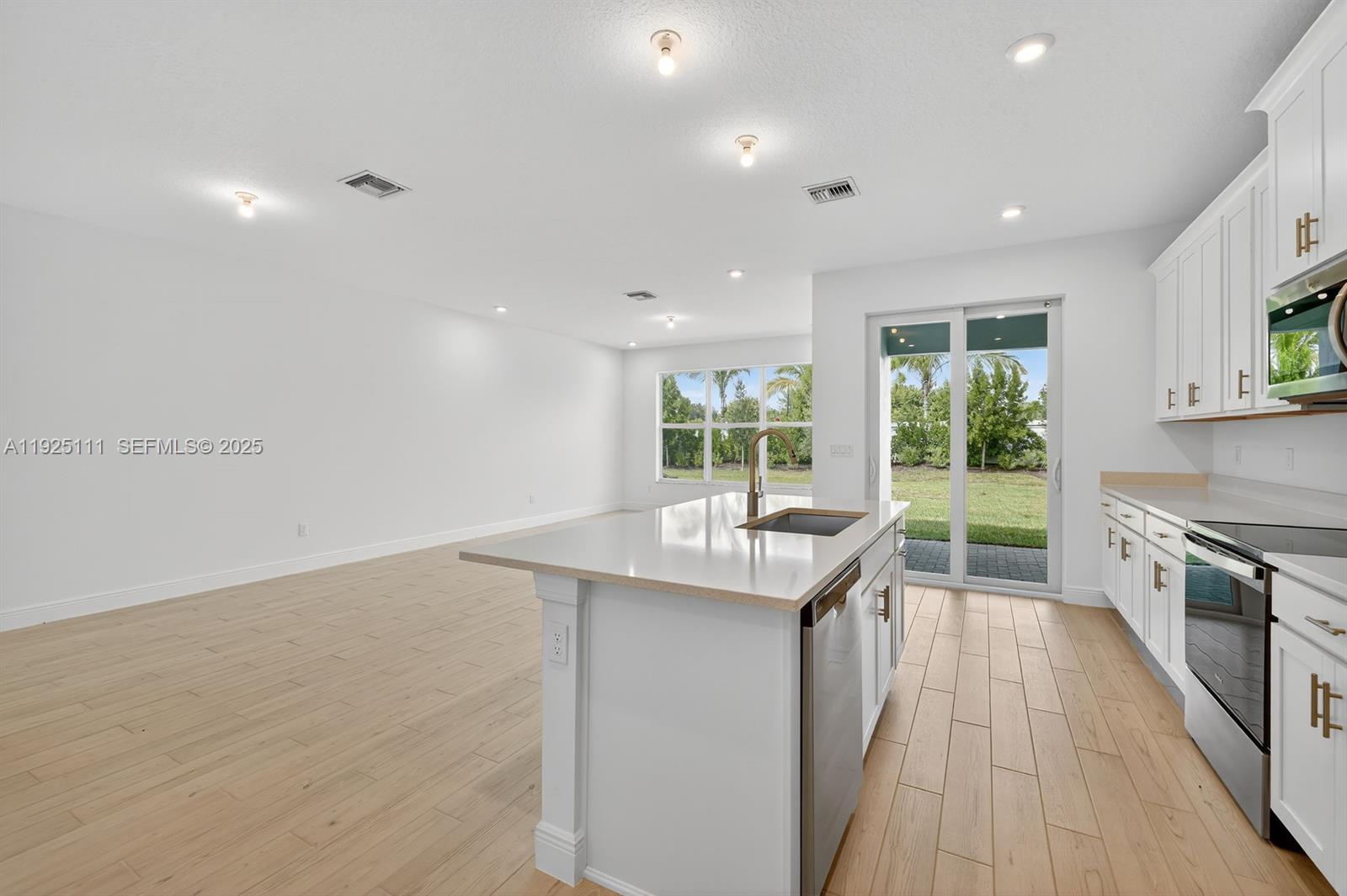 3585 Northwest Solange Court, Unit 3585 Jensen Beach, FL 34957 - Photo 13 of 33 a kitchen with kitchen island a sink and wooden floor