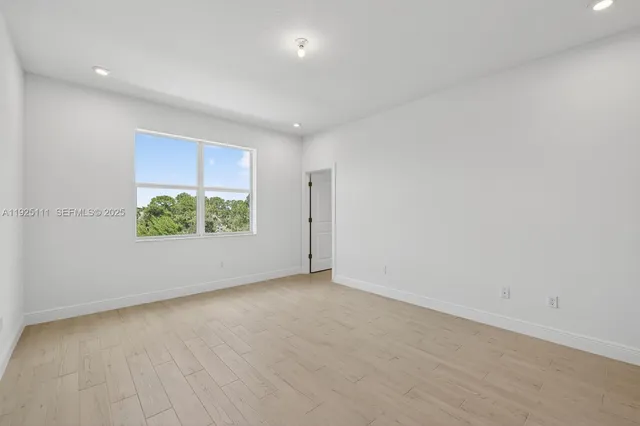 an empty room with potted plants and more wall