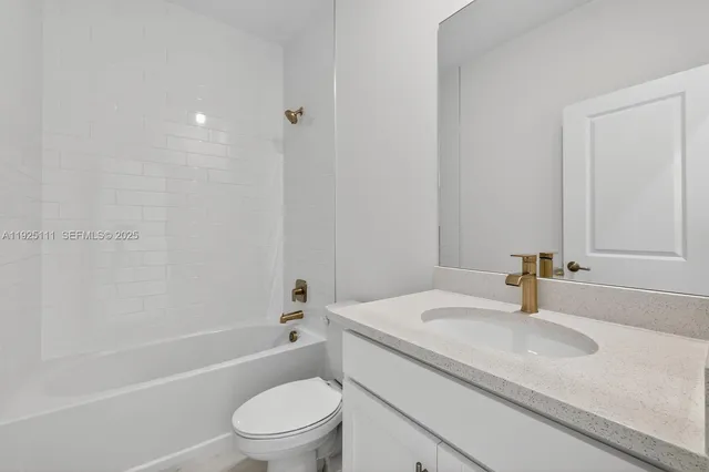 a bathroom with a granite countertop sink a toilet and shower