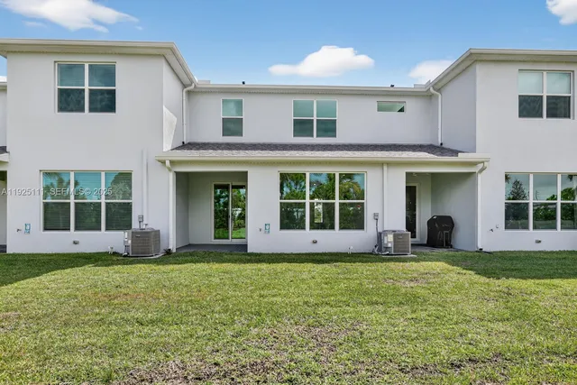 a view of a white house with a large garden and large windows