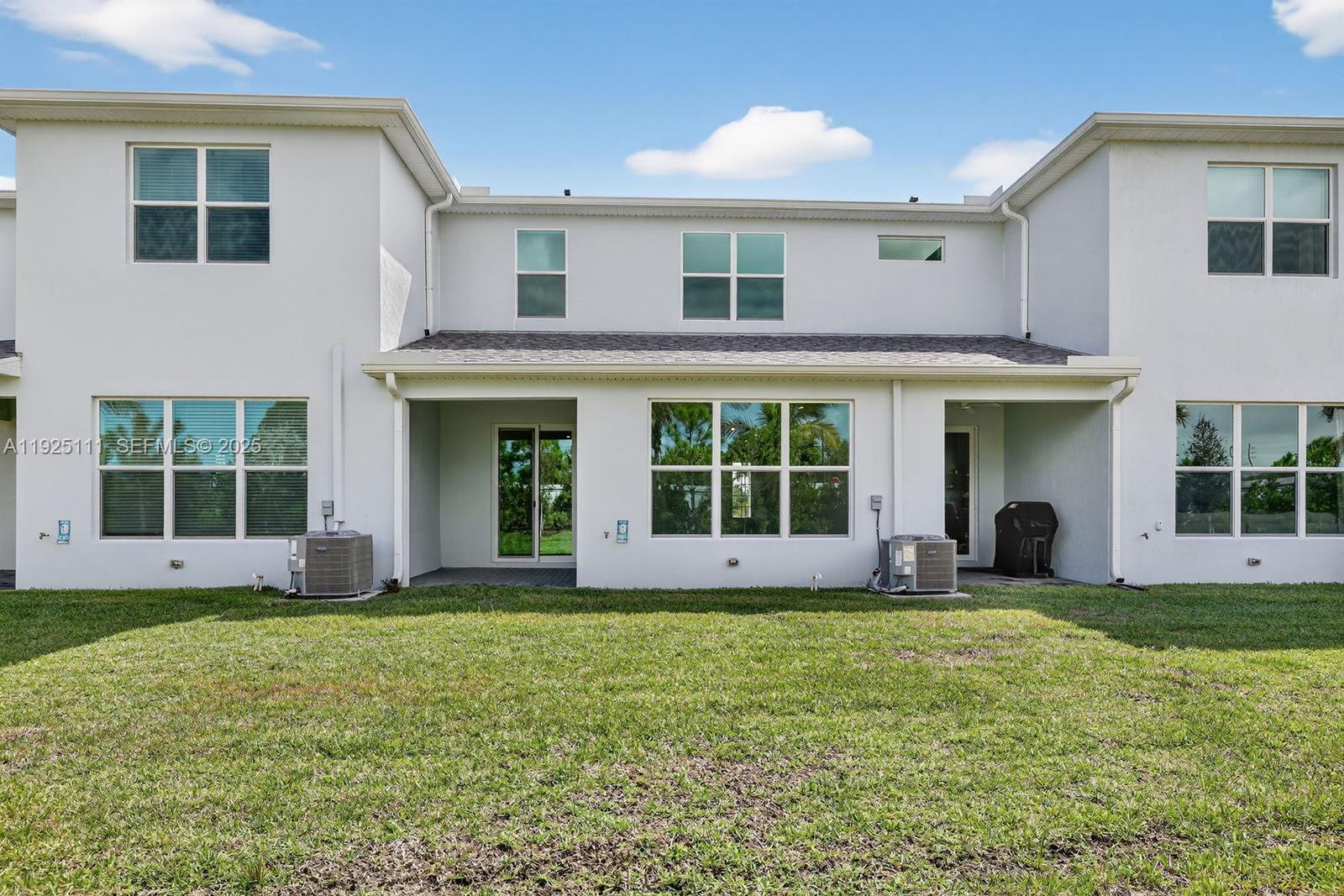 3585 Northwest Solange Court, Unit 3585 Jensen Beach, FL 34957 - Photo 31 of 33 a view of a white house with a large garden and large windows