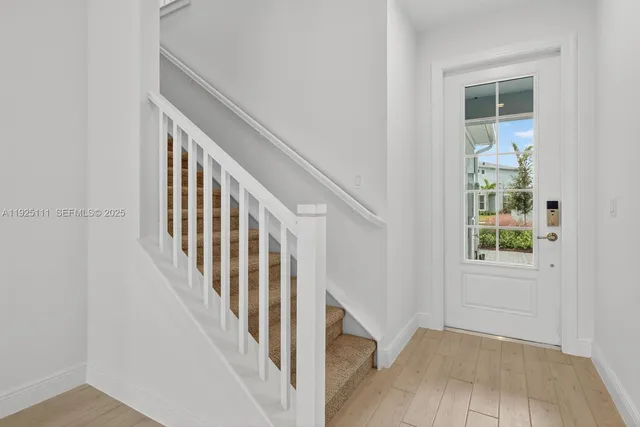 an entryway with wooden floor and stairs
