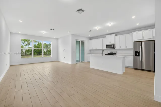 a view of kitchen with wooden floor and electronic appliances
