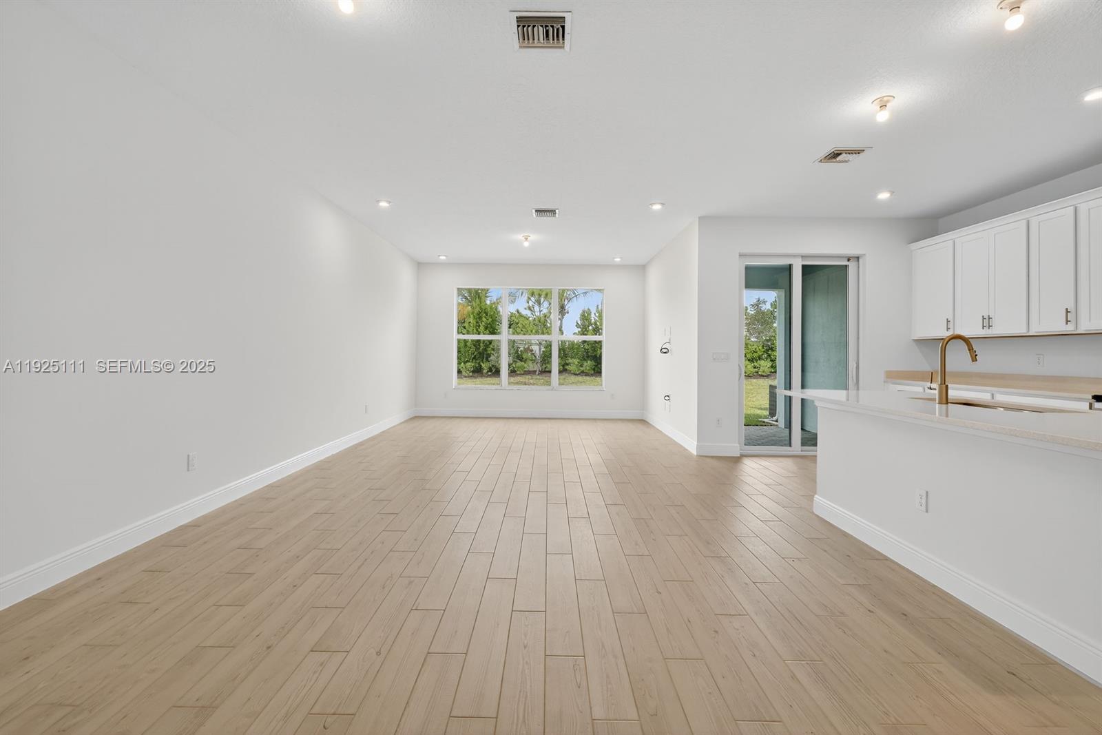 3585 Northwest Solange Court, Unit 3585 Jensen Beach, FL 34957 - Photo 7 of 33 an empty room with wooden floor and windows