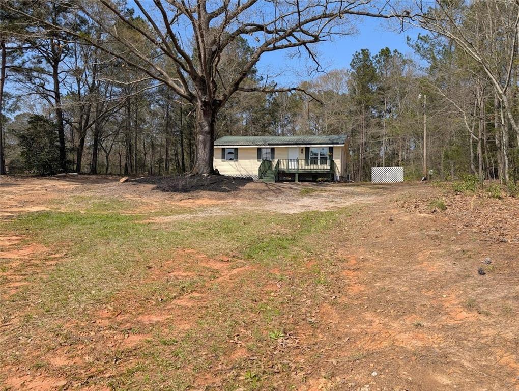 a front view of a house with a yard and trees