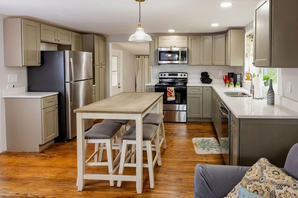 107 South Gates Road Pine Mountain, GA 31822 - Photo 6 of 18 a kitchen with stainless steel appliances granite countertop a refrigerator a stove top oven a sink dishwasher and white cabinets with wooden floor