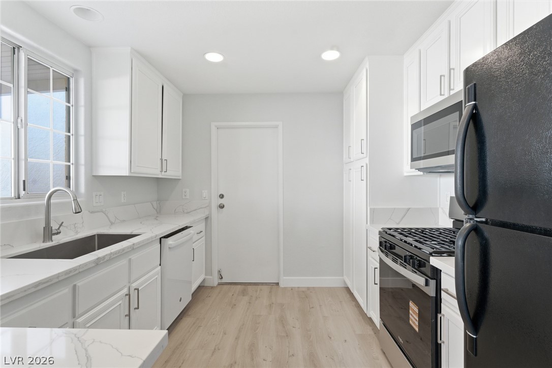 5449 Bugle Way, Unit 104 Las Vegas, NV 89108 - Photo 13 of 33 This modern kitchen features crisp white cabinetry, durable countertops, and sleek appliances.