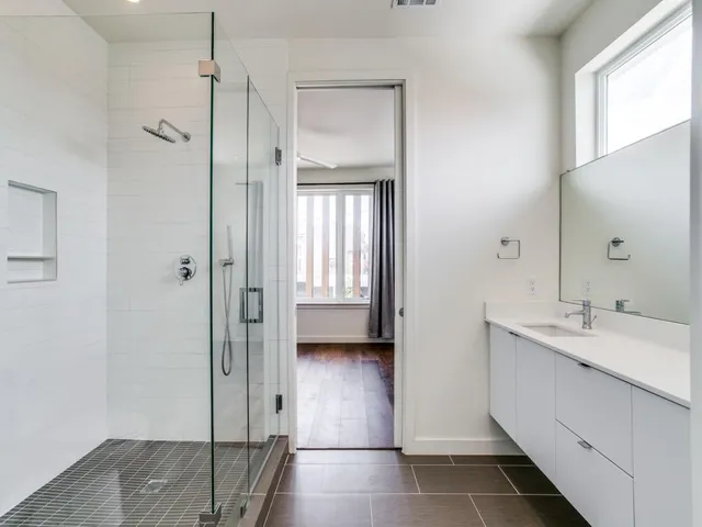 a bathroom with a double vanity sink a mirror and a shower