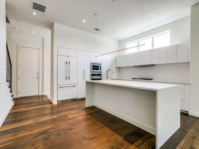 a kitchen with granite countertop a refrigerator and a sink